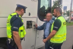 policjanci rozmawiają przed autobusem z kierowcą