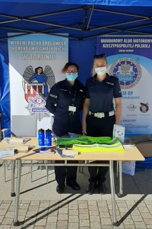 dwie policjantki stoją przy stoisku profilaktycznym