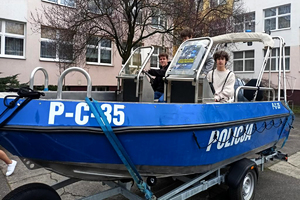 młodzież stoi w policyjnej łodzi