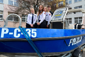 młodzież stoi w policyjnej łodzi